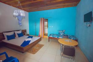 Habitación azul con cama y mesa en Hotel National Ambilobe, en Ambilobe