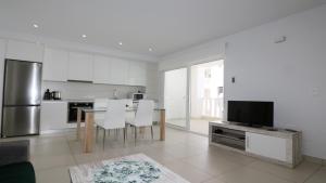 eine Küche mit einem Tisch mit Stühlen und einem TV in der Unterkunft REF 9959 Green Apartment La Marina in Elche