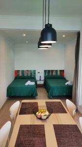 マルベーリャにあるApartment in Marbella-First Line Beach 11-9のベッド2台、テーブル(フルーツボウル付)が備わる客室です。