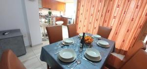 a table with a blue table cloth and a bowl of fruit at Vasilas Holiday Apartment #2 in Larnaca