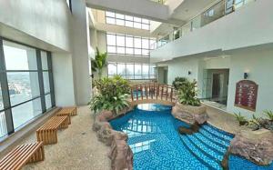 a large swimming pool in a building with benches at Comfy Bunkbed with Pool in Manila