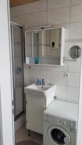 ein Badezimmer mit einem Waschbecken und einer Waschmaschine in der Unterkunft Ferienwohnung "Aloki" in Sankt Peter-Ording