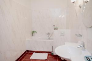een witte badkamer met een wastafel en een bad bij Landgoed Halsaf in Babberich