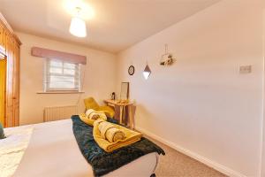 Un dormitorio con una cama con toallas amarillas. en Elite 15 Stays, en Whitley Bay