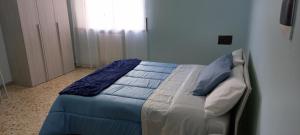 a bedroom with a bed with blue sheets and a window at Viviana in Naples