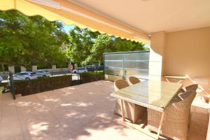 a patio with a table and chairs and a view of a parking lot at Apartamento Golden Beach in Jávea