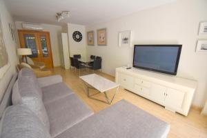 a living room with a couch and a flat screen tv at Apartamento Golden Beach in Jávea