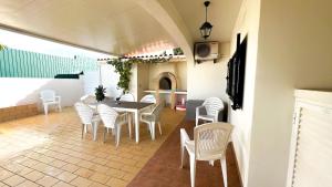 a dining room with a table and white chairs at Villa Gilsónia by Sunny Deluxe in Guia