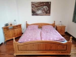 1 dormitorio con 1 cama de madera y 2 mesitas de noche en Property in Falkenstein, en Falkenstein