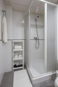 uma casa de banho branca com um chuveiro e um WC. em Algaba 3 D planta em La Algaba