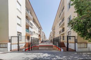 un callejón entre dos edificios de apartamentos con una puerta en Algaba 3 D planta en La Algaba