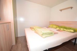 uma cama num quarto com almofadas amarelas em Campsite Pisak - mobile homes by the sea em Seline