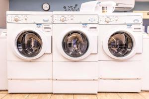 two washing machines stacked up in a laundry room at Sonesta Simply Suites Plano Frisco in Plano
