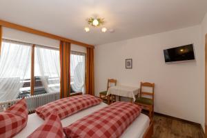 a hotel room with two beds and a window at Hotel Binderhäusl in Berchtesgaden
