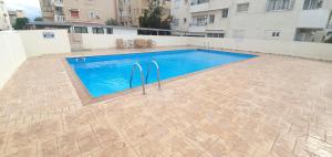 a swimming pool in the middle of a building at Vasilas Holiday Apartment #2 in Larnaca