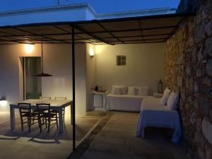 un patio con cama, mesa y sillas en Relais Masseria Sant'Antonio, en Marina di Pescoluse