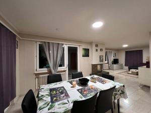 ein Esszimmer mit einem Tisch und Stühlen sowie ein Wohnzimmer in der Unterkunft Specious 5.5 rooms garden house @ Wallisellen in Wallisellen