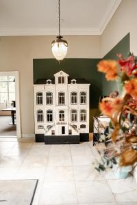 a white doll house in a room with a plant at Landgoed Halsaf in Babberich