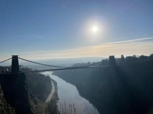 a bridge over a river with the sun in the sky at Gated Stunning Period Studio in Vibrant Bristol in Bristol