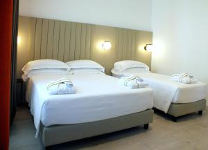 two beds in a hotel room with white sheets and pillows at BB Hotels Smarthotel Derose in Florence +19 photos