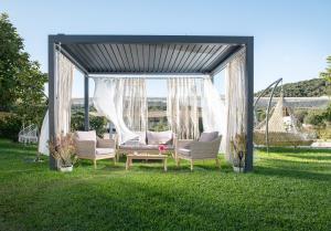 a gazebo with chairs and a table in the grass at Notia Luxury Living in Porto Koufo