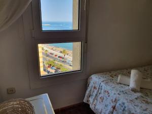 una camera da letto con finestra affacciata sulla spiaggia di VIVE BENALMÁDENA BENAL BEACH 1-807. Vistas al mar, parque acuático familiar a Benalmádena