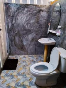 a bathroom with a toilet and a sink at Mook Happy Bungalow in Koh Mook