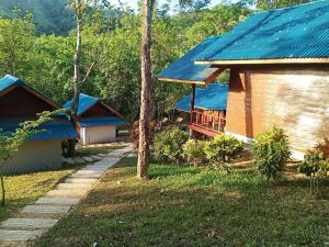 a group of houses with blue roofs in a forest at Mook Happy Bungalow in Koh Mook +10 photos