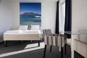 a bedroom with a bed and a table and chairs at P-Hotels Brattøra in Trondheim