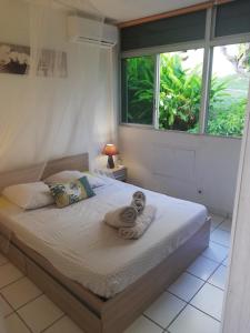 um quarto com uma cama com toalhas em "Le Caraïbe" T3 à Bas du Fort au Gosier à quelques pas de la plage em Le Gosier