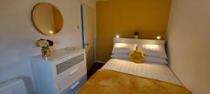 a small bedroom with a bed and a mirror at The Tackeroo Suite in Hednesford