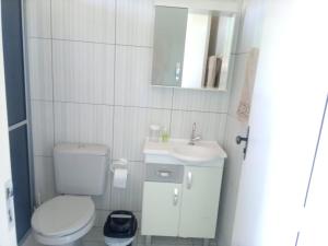 a small bathroom with a toilet and a sink at Pousada Tradição in Gramado
