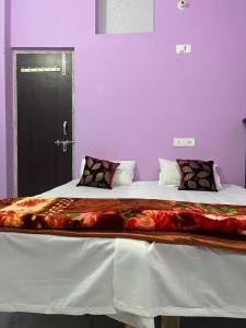 a large bed in a room with purple walls at Riru girlstay in Patna