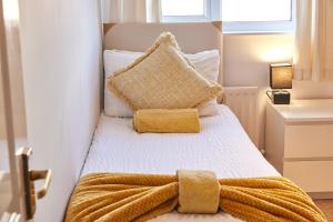 a bedroom with a bed with a yellow blanket on it at Elite 15 Stays in Whitley Bay