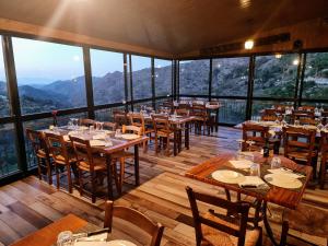 a restaurant with tables and chairs with mountains in the background at Perneia Rooms in Askas