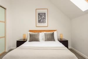 een slaapkamer met een groot bed met 2 nachtkastjes bij The Modern Mill Apartment in Edinburgh