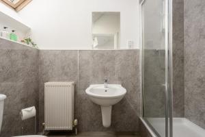 y baño con lavabo y ducha. en The Modern Mill Apartment, en Edimburgo