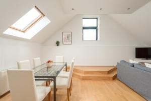 a dining room with a table and a couch at The Modern Mill Apartment in Edinburgh