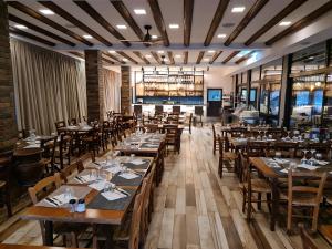 a dining room with wooden tables and chairs at Perneia Rooms in Askas