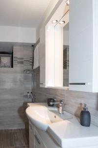 uma casa de banho com um lavatório branco e um espelho. em Kalimera Villa, Afissos Pelion em Afissos