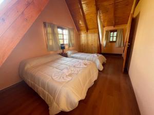 2 camas en un dormitorio con techos de madera en Náutico Apart Hotel en Chascomús
