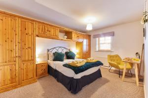 1 dormitorio con 1 cama con armarios de madera y escritorio en Elite 15 Stays, en Whitley Bay