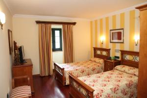 a hotel room with two beds and a window at Posada Casa de don Guzman in Vega de Pas