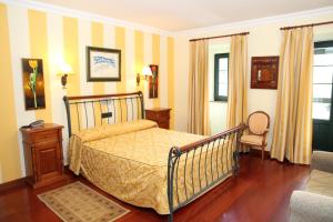 1 dormitorio con 1 cama y 1 silla en Posada Casa de don Guzman en Vega de Pas