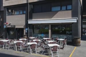 a bunch of tables and chairs in front of a building at Pension Guria Jatetxea in Urnieta