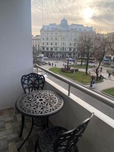 a table and chairs on a balcony with a view of a building at Avenue Apart in Lviv