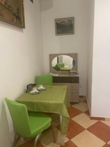 a room with a table and green chairs and a mirror at Viktoria in Vienna
