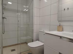 y baño blanco con aseo y ducha. en Apartamentos Picasso, en Alcalá de Henares