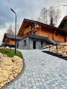 a large log cabin with a stone driveway at Chalet Rozmarin Predeal in Predeal