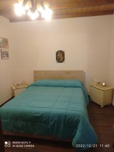 una camera con letto e piumone blu di Chalet immerso nel Bosco a Melfi